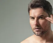Homem a tocar no queixo (efeitos da cirurgia de mentoplastia)